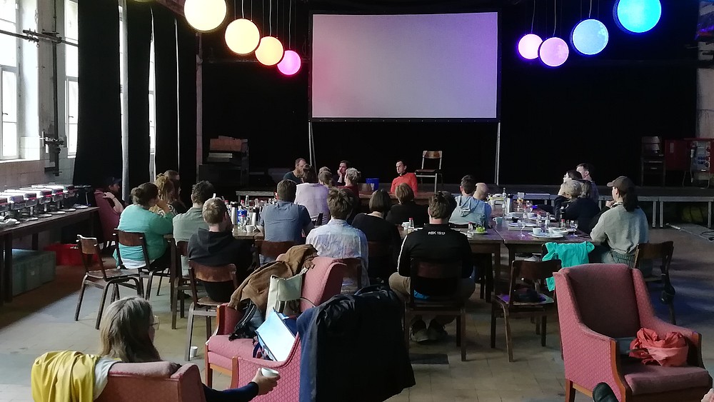 In einem Raum im Kulturhaus sitzen Alumni und HSZG-Mitarbeiter an Tischen und tauschen sich aus.