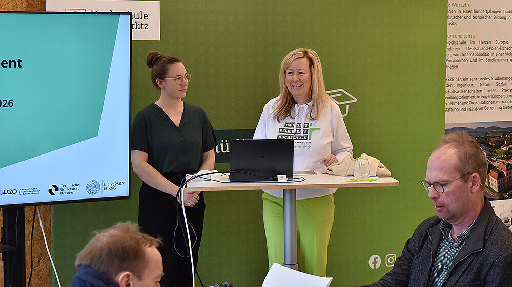 Prorektorin Prof. Dr. Sophia Keil steht beim Workshop Einführung in das Forschungsdatenmanagement vor einer grünen Pressewand und spricht zu den Teilnehmenden.