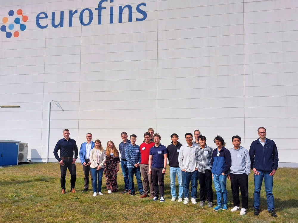 Ein Gruppenfoto vor einem großen weißen Gebäude mit der Aufschrift Eurofins
