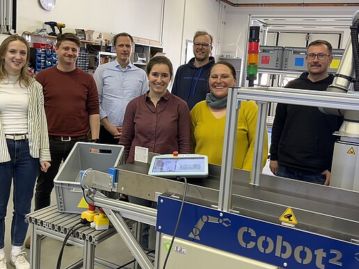 Projektbeteigte Menschen vor der Cobot-Anlage