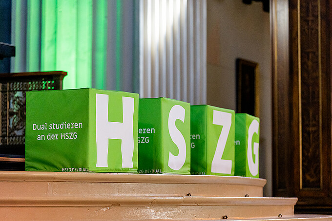Vier grüne Würfel mit den weißen Buchstaben H, S, Z und G stehen auf den Stufen im Altarraum der Johanniskirche.