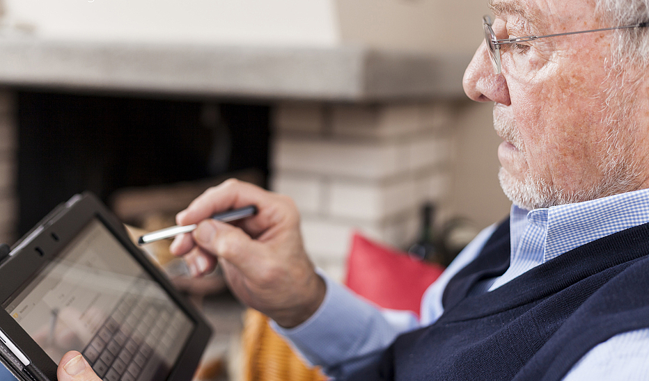 Foto: ASK-Fotografie-Fotolia.com Älterer Mann nutzt einen Eingabestift auf einem Tablett.
