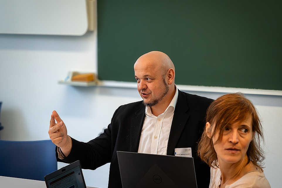 Prof. Schmidt diskutiert am Tisch.
