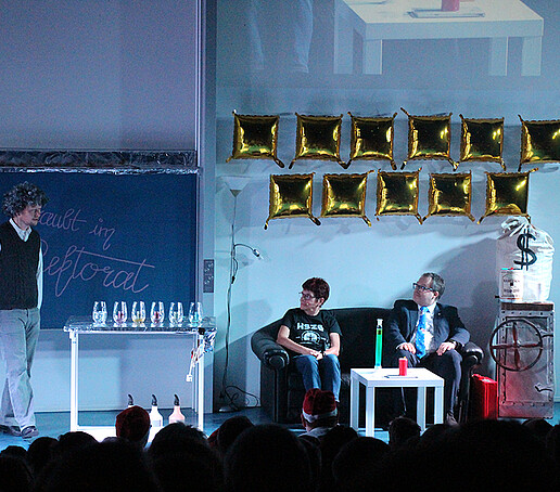 Frau Hollstein und der Rektor unterhalten sich mit einem Darsteller.