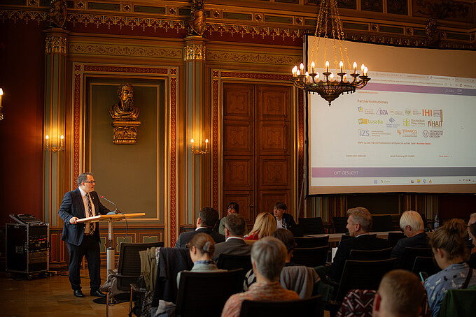 Der Rektor hält im Bürgersaal ein Grußwort am Rednerpult.