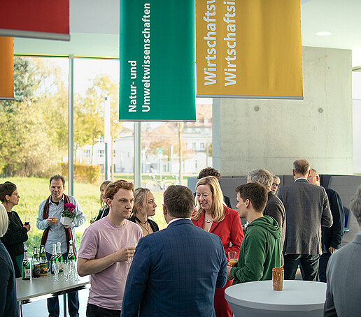 Gäste der Veranstaltung sind im Gespräch vertieft.