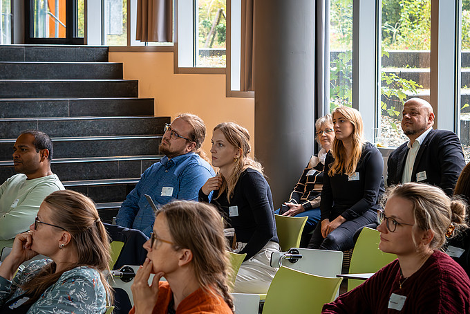 Teilnehmende des Workshops hören dem Vortragenden aufmerksam zu.